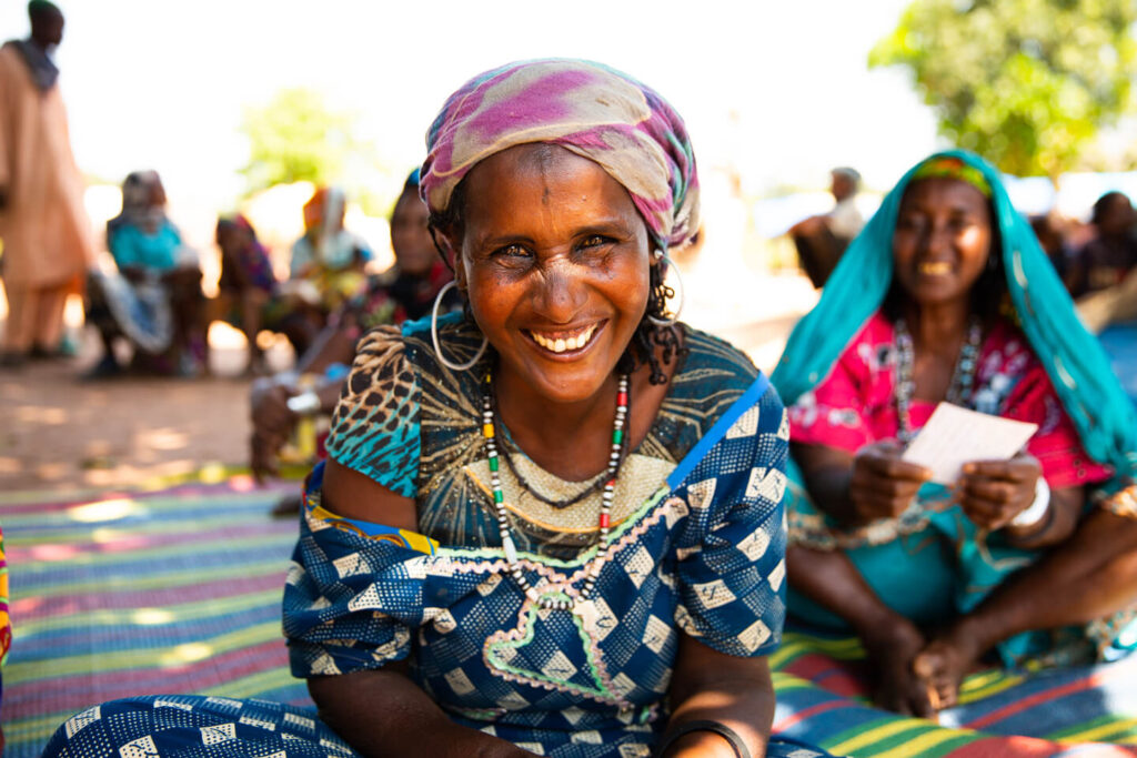 Person sitting on ground smiling