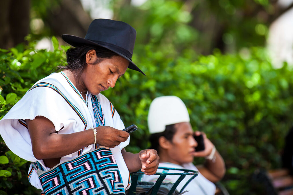 Two people sitting while on cell phones