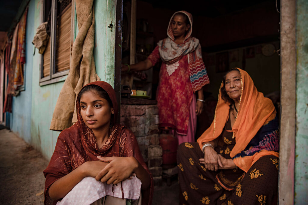 three women sitting in a doorway