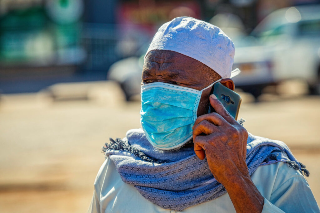 man talking on a phone while wearing a mask