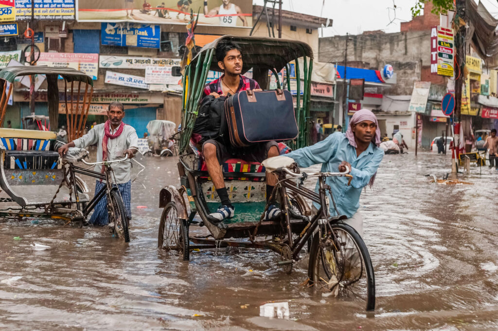 People and bikes in water on a flooded street