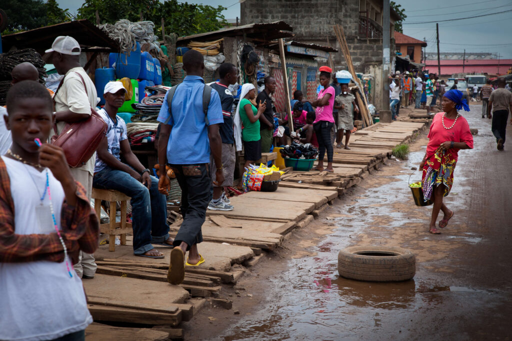 People standing along a street with goods